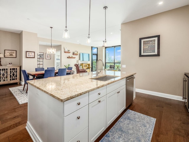 kitchen featuring white cabinetry, stainless steel dishwasher, a center island with sink, and sink