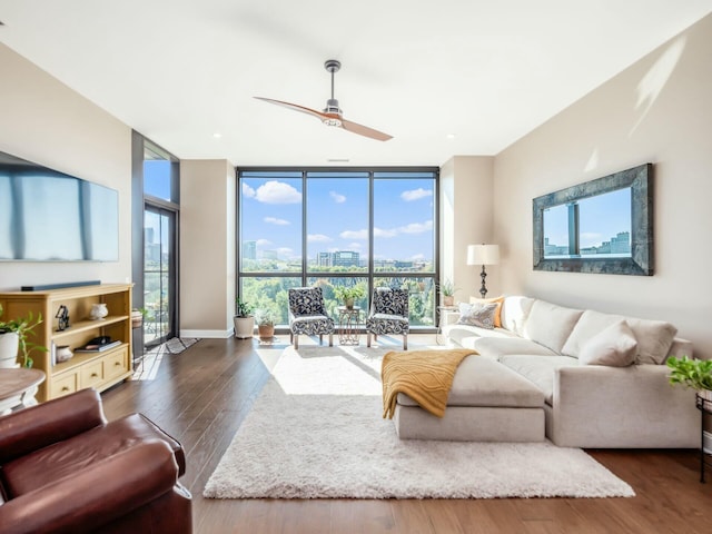 living room featuring ceiling fan, expansive windows, and a healthy amount of sunlight