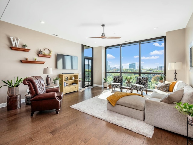 living room featuring ceiling fan, hardwood / wood-style flooring, and expansive windows