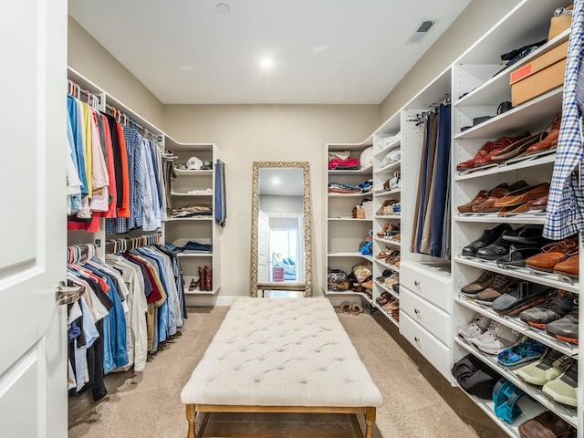 walk in closet featuring light colored carpet