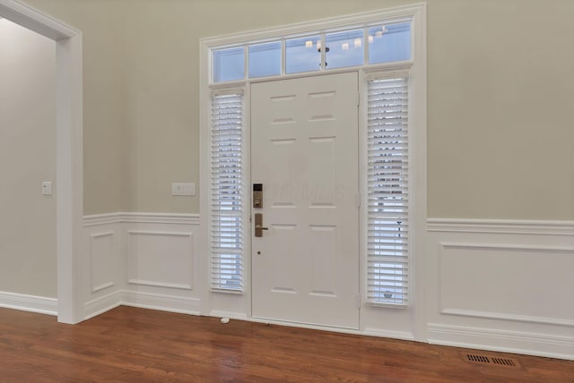 entrance foyer with dark hardwood / wood-style flooring and a healthy amount of sunlight