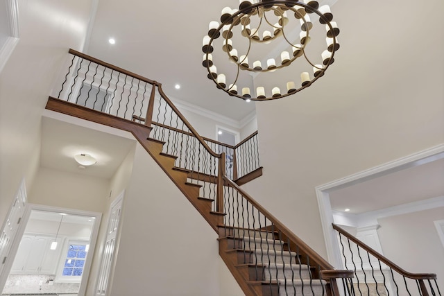 stairway featuring a high ceiling and ornamental molding