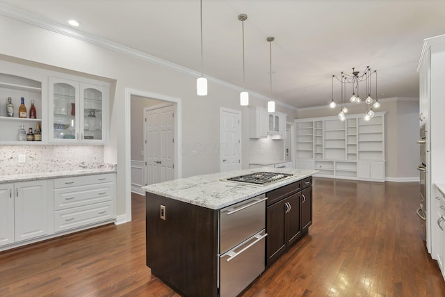 kitchen featuring white cabinetry, a center island, pendant lighting, stainless steel gas stovetop, and dark brown cabinets