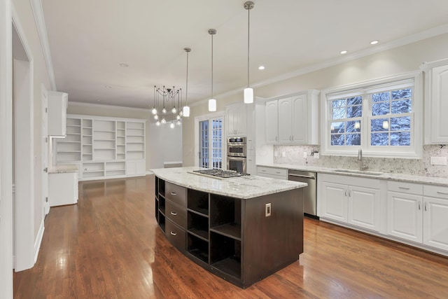 kitchen featuring white cabinets, sink, a kitchen island, light stone counters, and stainless steel appliances