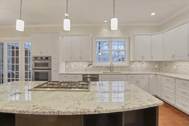 kitchen with white cabinetry, sink, stainless steel appliances, pendant lighting, and decorative backsplash