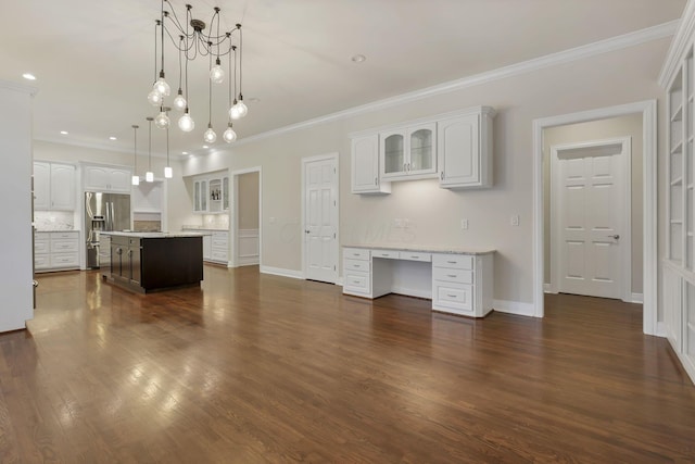 kitchen with a center island, an inviting chandelier, stainless steel fridge, pendant lighting, and white cabinets