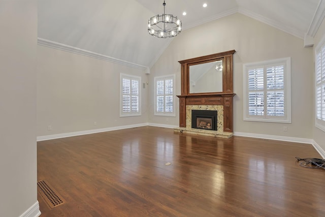 unfurnished living room featuring a notable chandelier, ornamental molding, a fireplace, and dark wood-type flooring