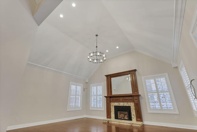 unfurnished living room featuring ornamental molding, high vaulted ceiling, a chandelier, and wood-type flooring