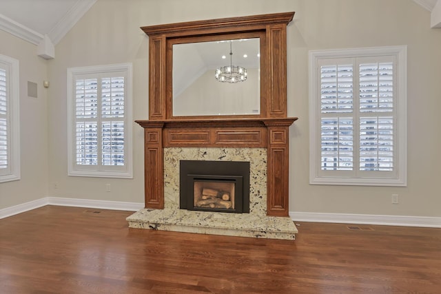 unfurnished living room with a high end fireplace, vaulted ceiling, crown molding, hardwood / wood-style flooring, and a chandelier