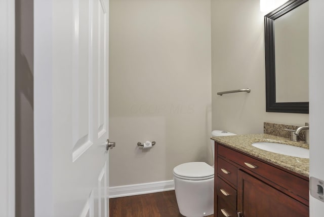 bathroom with hardwood / wood-style floors, vanity, and toilet