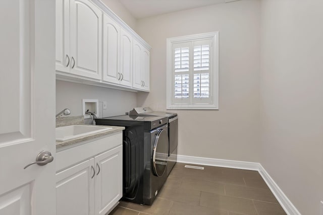 clothes washing area with cabinets, independent washer and dryer, sink, and light tile patterned floors