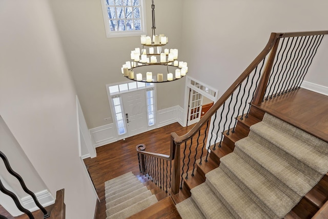 entrance foyer with dark wood-type flooring, plenty of natural light, and a notable chandelier