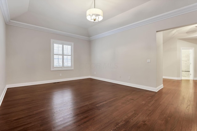 empty room featuring dark hardwood / wood-style floors, crown molding, and a tray ceiling