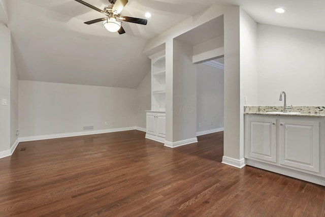 bonus room featuring built in shelves, ceiling fan, sink, dark hardwood / wood-style floors, and lofted ceiling