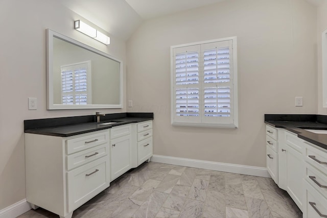 bathroom featuring vanity, lofted ceiling, and a wealth of natural light