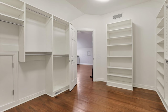 spacious closet with dark hardwood / wood-style flooring and lofted ceiling