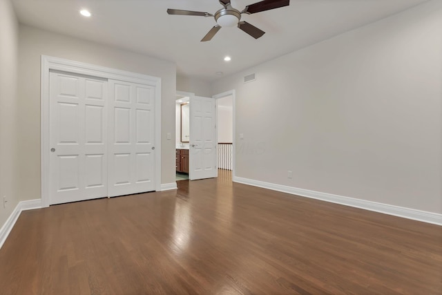 unfurnished bedroom with ceiling fan, dark wood-type flooring, and a closet