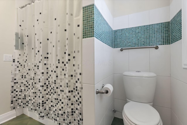 bathroom featuring a shower with shower curtain, toilet, and tile walls