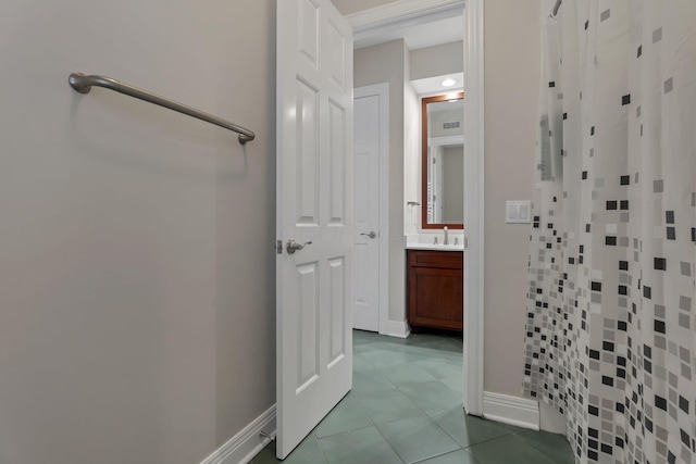 bathroom featuring tile patterned floors, vanity, and curtained shower