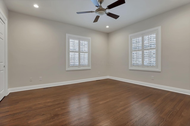 empty room featuring dark hardwood / wood-style flooring, plenty of natural light, and ceiling fan