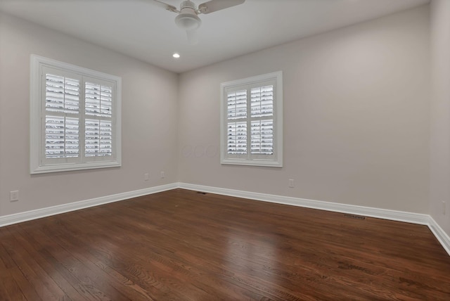 empty room with ceiling fan and dark hardwood / wood-style flooring