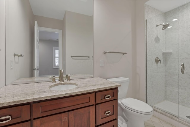 bathroom featuring tile patterned floors, vanity, toilet, and a shower with door