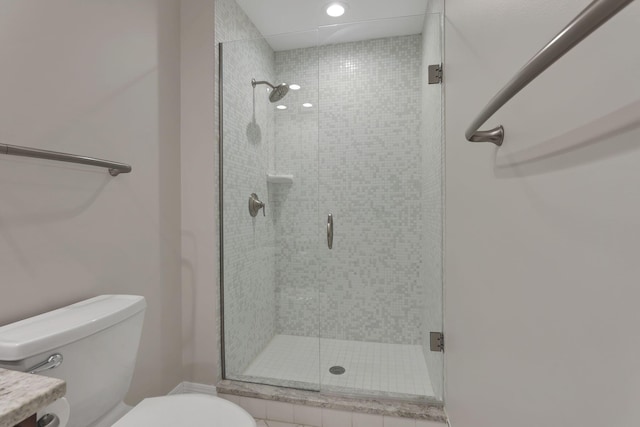 bathroom featuring vanity, toilet, and a shower with shower door