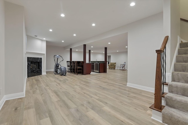 living room featuring a high end fireplace and light hardwood / wood-style floors