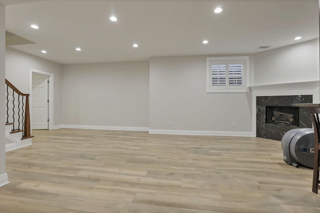 living room with light hardwood / wood-style flooring and a high end fireplace