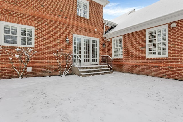 snow covered house with french doors