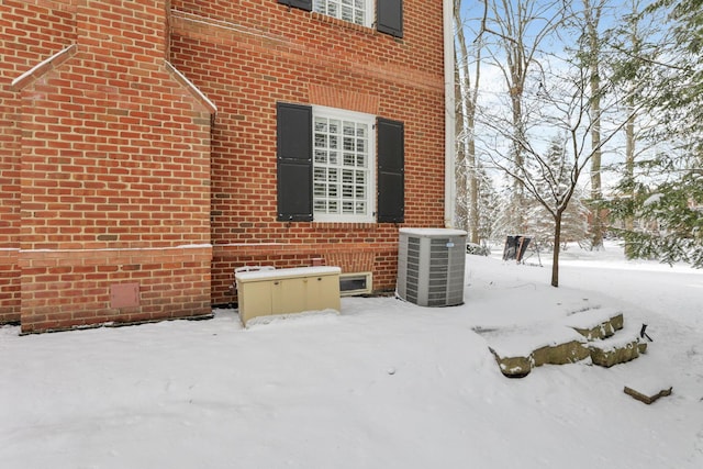 snow covered property featuring central air condition unit