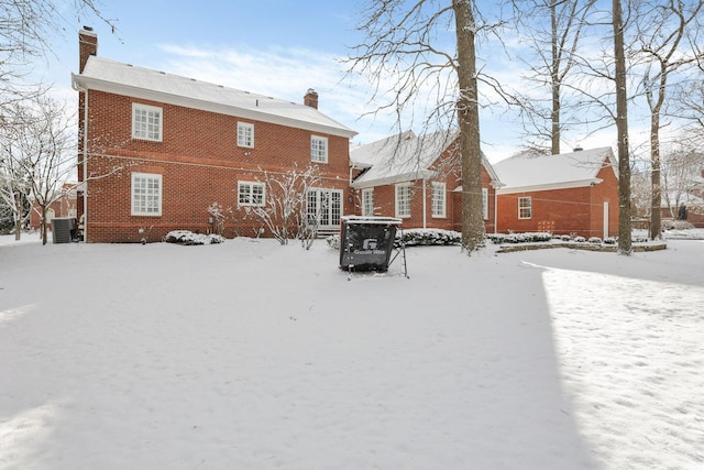 snow covered back of property featuring cooling unit