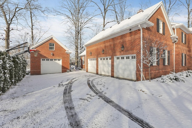 view of snow covered exterior with a garage