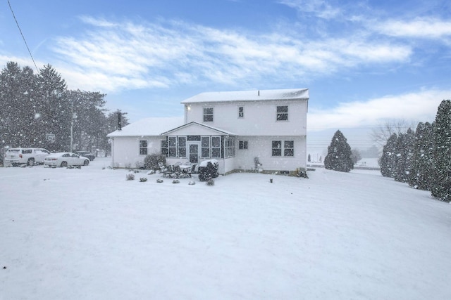 snow covered property with a sunroom