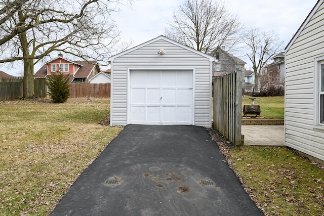 detached garage with aphalt driveway and fence