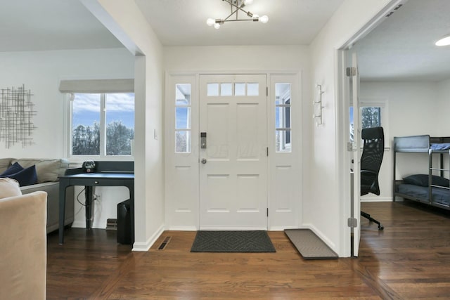 entryway featuring dark hardwood / wood-style floors and an inviting chandelier