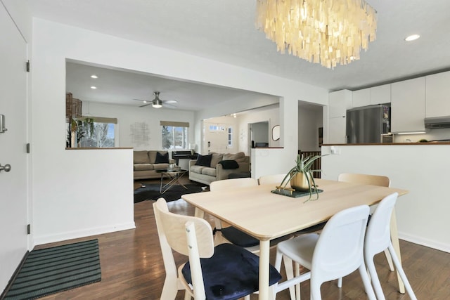 dining room featuring dark hardwood / wood-style flooring and ceiling fan with notable chandelier