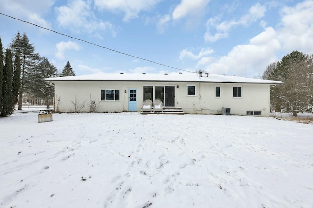 snow covered property featuring central AC