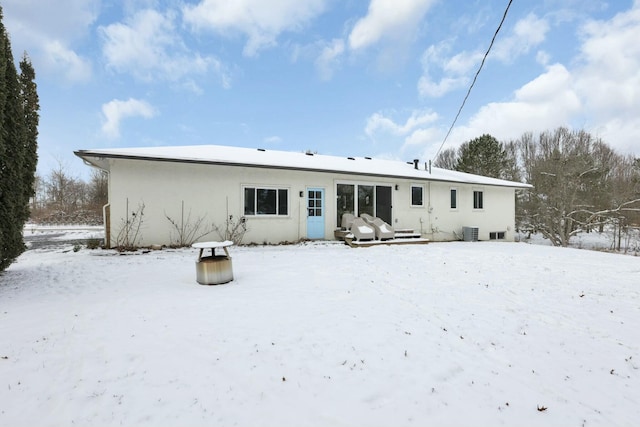 snow covered rear of property with central AC