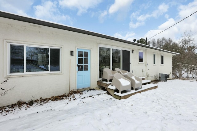 snow covered property featuring central AC