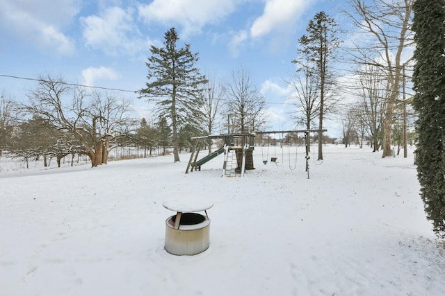 yard layered in snow featuring a playground