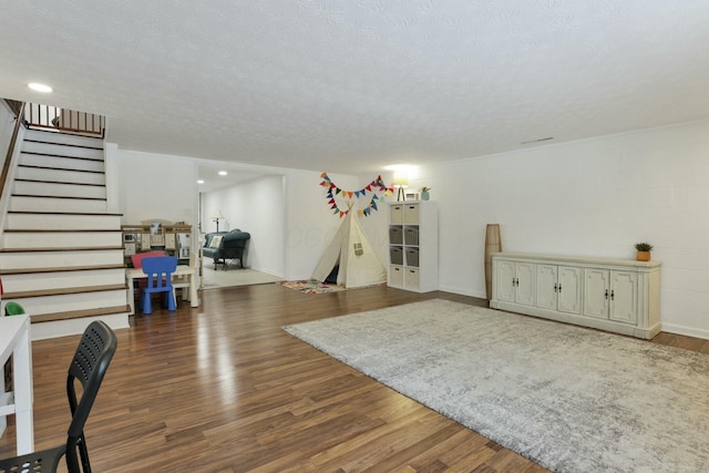 rec room with dark hardwood / wood-style flooring and a textured ceiling