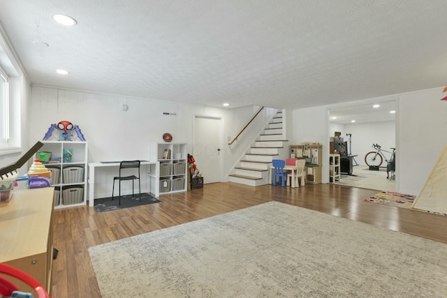 rec room with hardwood / wood-style floors and a textured ceiling