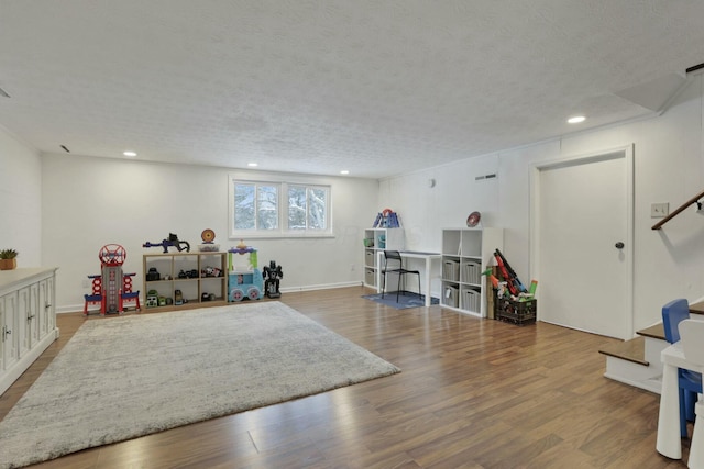 playroom with wood-type flooring and a textured ceiling