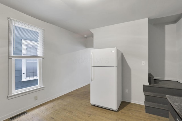 kitchen featuring white refrigerator and light hardwood / wood-style flooring