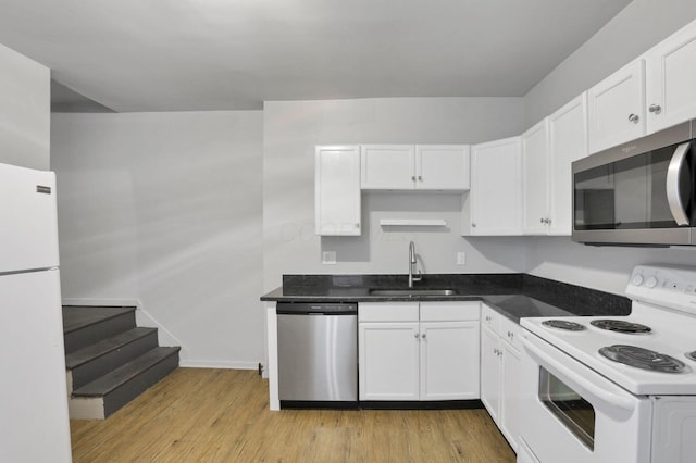 kitchen with white cabinets, light wood-type flooring, stainless steel appliances, and sink