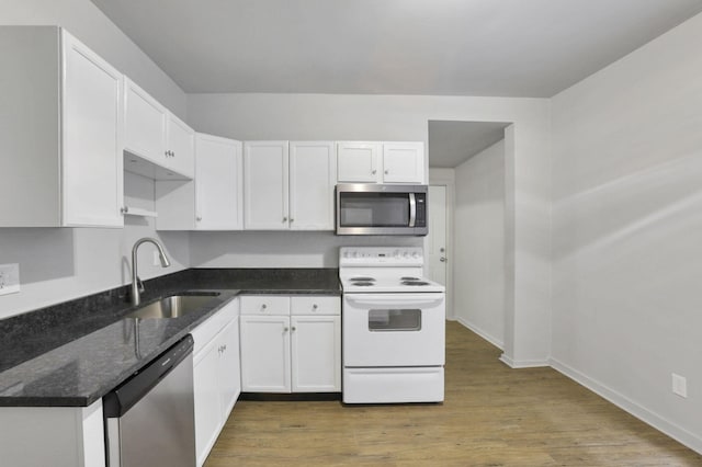 kitchen with hardwood / wood-style flooring, sink, white cabinets, and appliances with stainless steel finishes