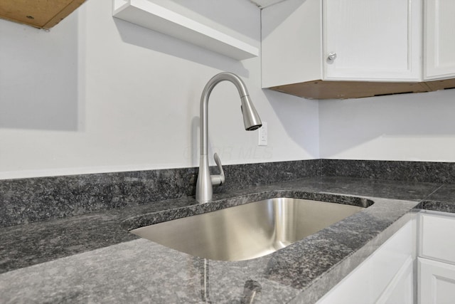 interior details with white cabinetry and sink