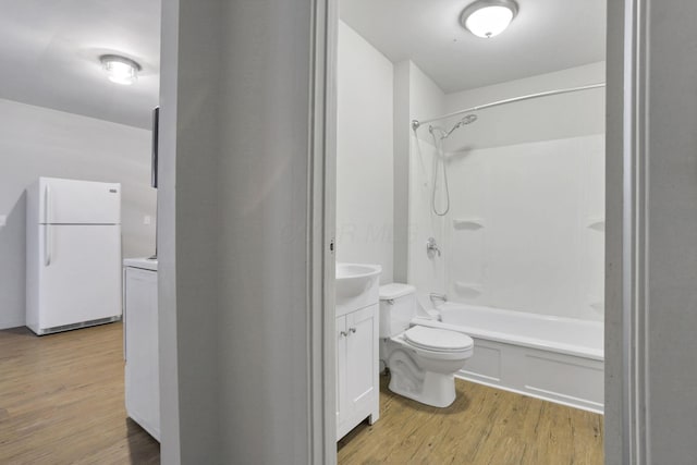 full bathroom with bathing tub / shower combination, vanity, hardwood / wood-style flooring, and toilet