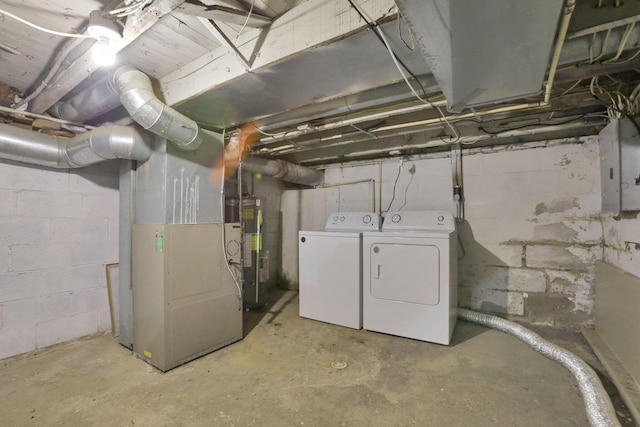 basement with washing machine and dryer, water heater, electric panel, and heating unit